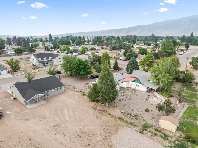 Expansive property featuring a newly constructed single-story residence with a covered porch and dark shingle roof