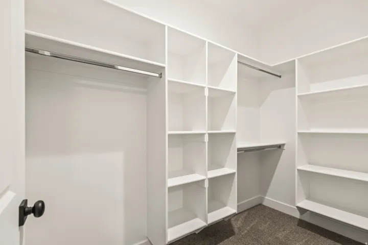 Custom-designed closet system featuring white shelving and hanging rods