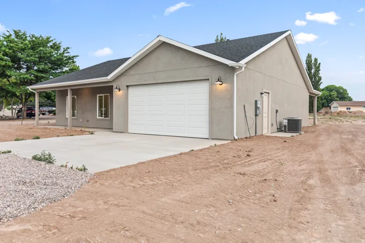 Contemporary stucco exterior with an attached garage, covered front porch, and concrete driveway
