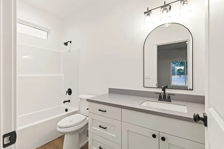 Contemporary bathroom featuring a white vanity with shaker-style cabinetry, a light gray countertop, and an undermount sink