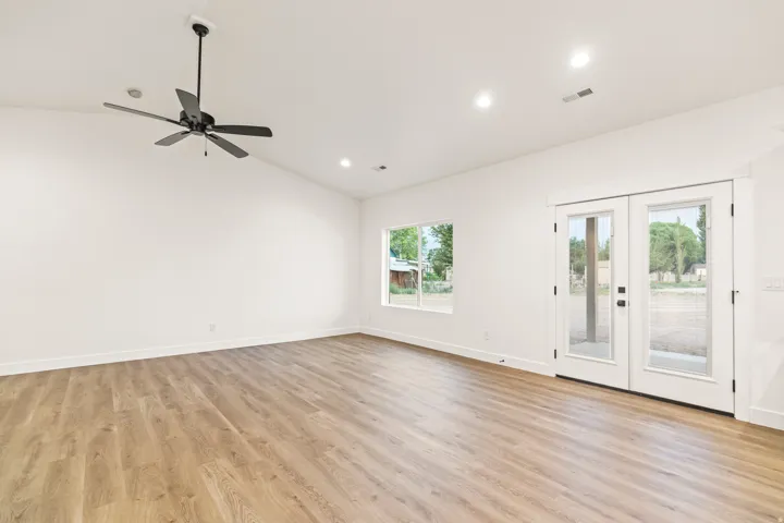 Spacious room featuring wood-finish flooring, vaulted ceilings, and recessed lighting