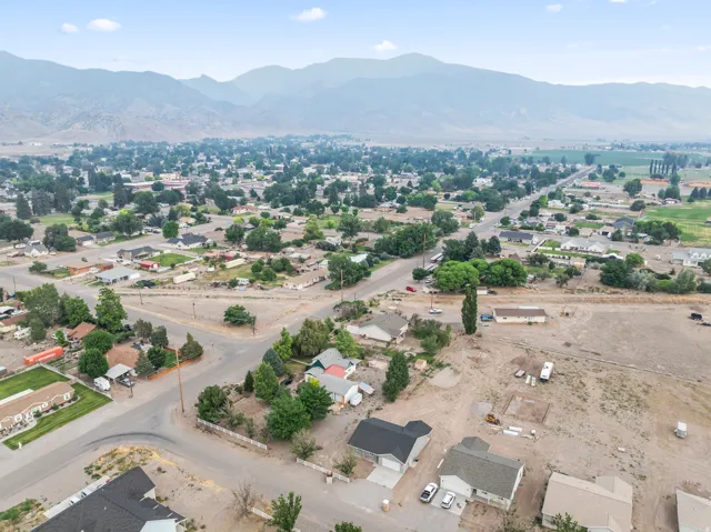 Expansive lot featuring a clear, level building area with surrounding residential properties and mature trees