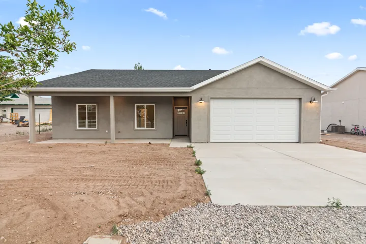 Contemporary single-story residence featuring a stucco exterior, a two-car garage, and a covered porch