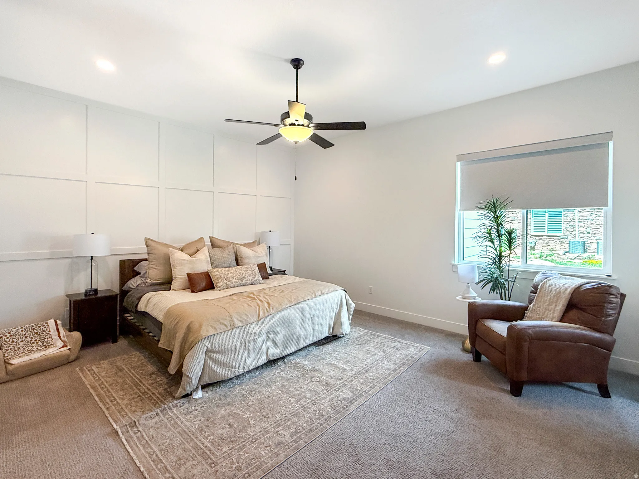 Spacious room featuring a decorative accent wall, ceiling fan with integrated lighting, recessed lighting, and ample natural light from a large window