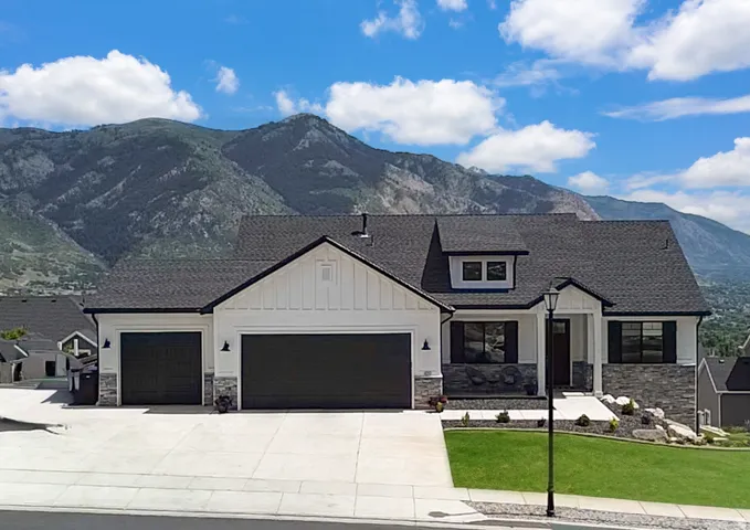 Contemporary facade with white vertical siding and dark stone accents