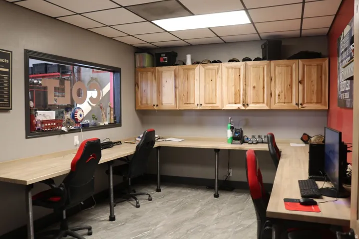 Versatile workspace featuring extensive light wood cabinetry, expansive light wood-finish countertops, and durable gray tile flooring