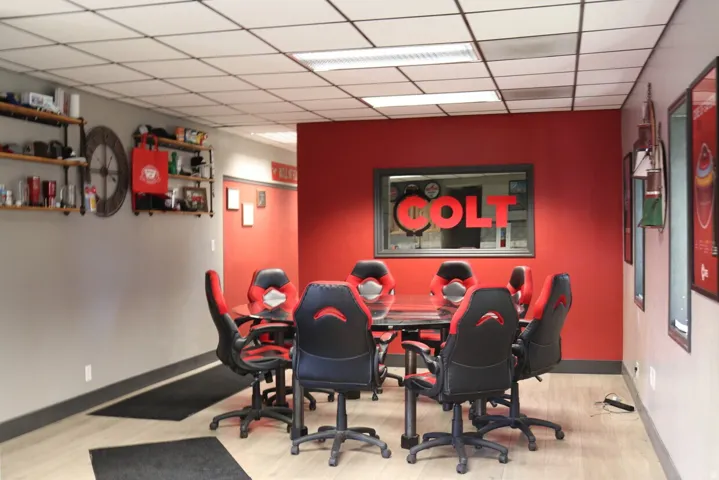 Conference area featuring a dropped ceiling with integrated lighting, wood-finish flooring, and a window opening to an interior space