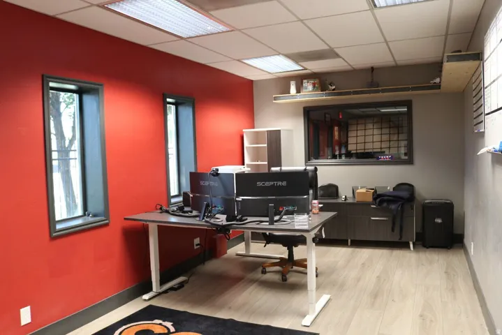 Spacious interior room featuring wood-finish flooring, recessed lighting, and multiple windows