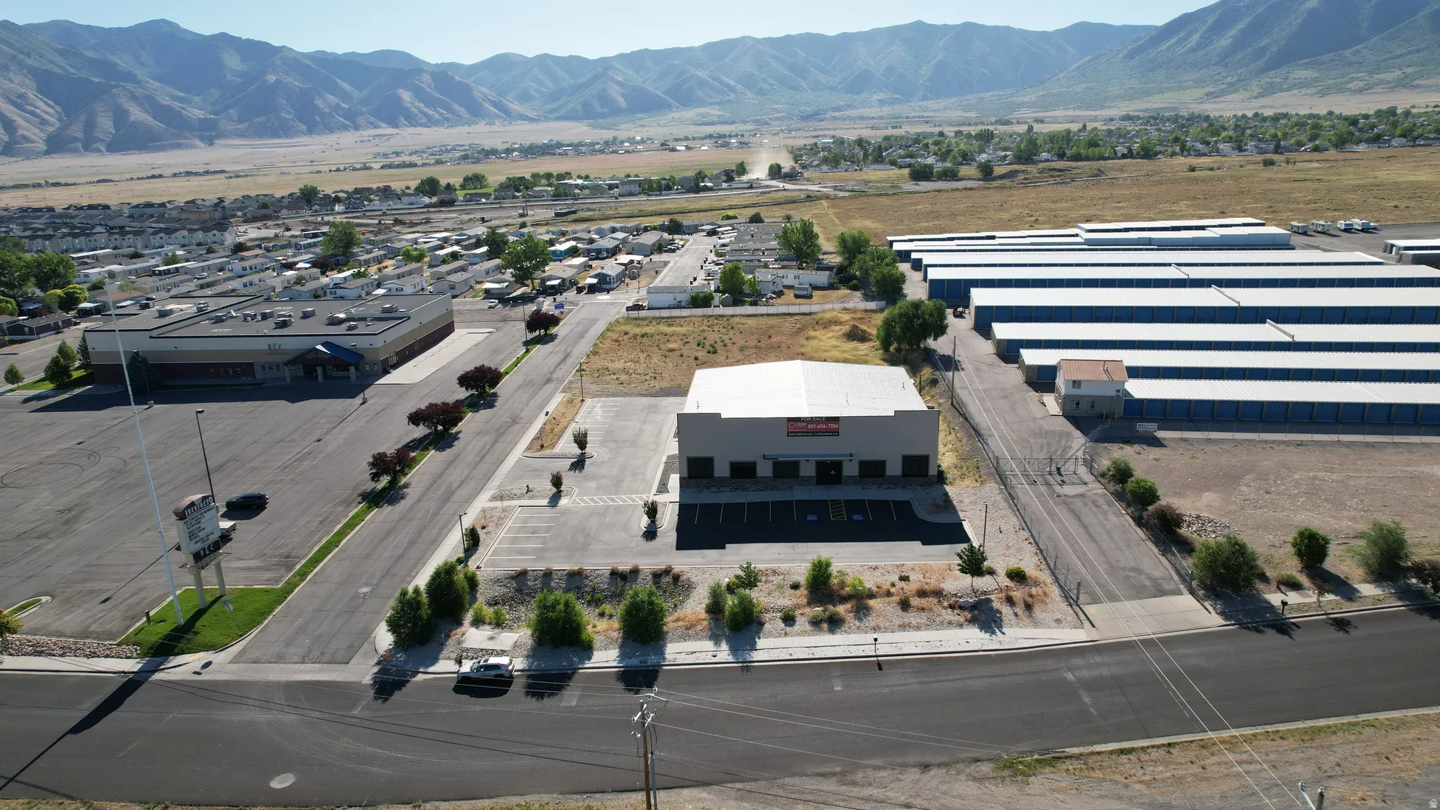 Commercial property featuring a large asphalt parking lot and mature landscaping