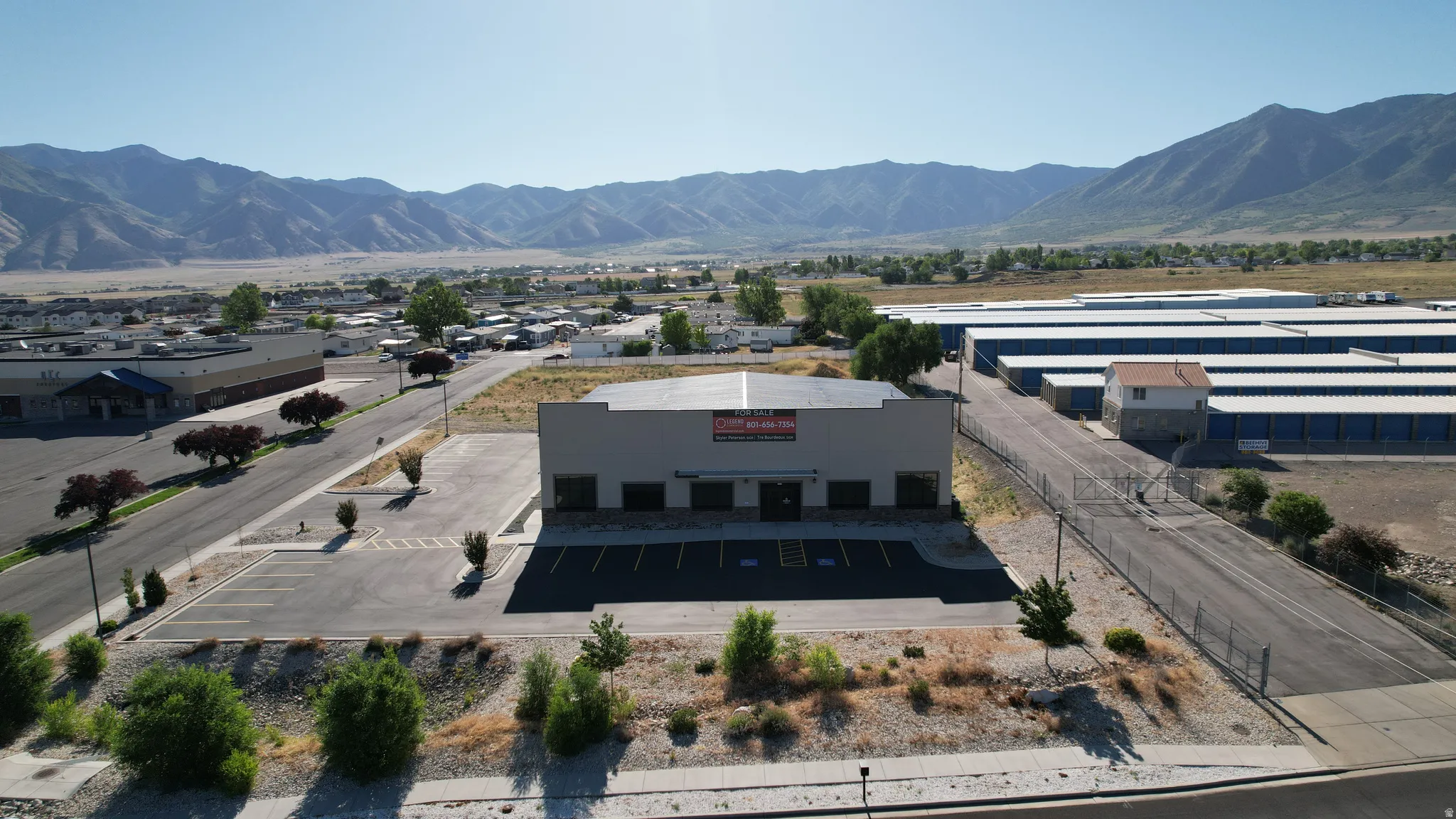 Commercial building featuring a flat roof and a paved parking lot with multiple spaces