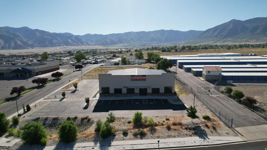 Commercial building featuring a flat roof and a paved parking lot with multiple spaces