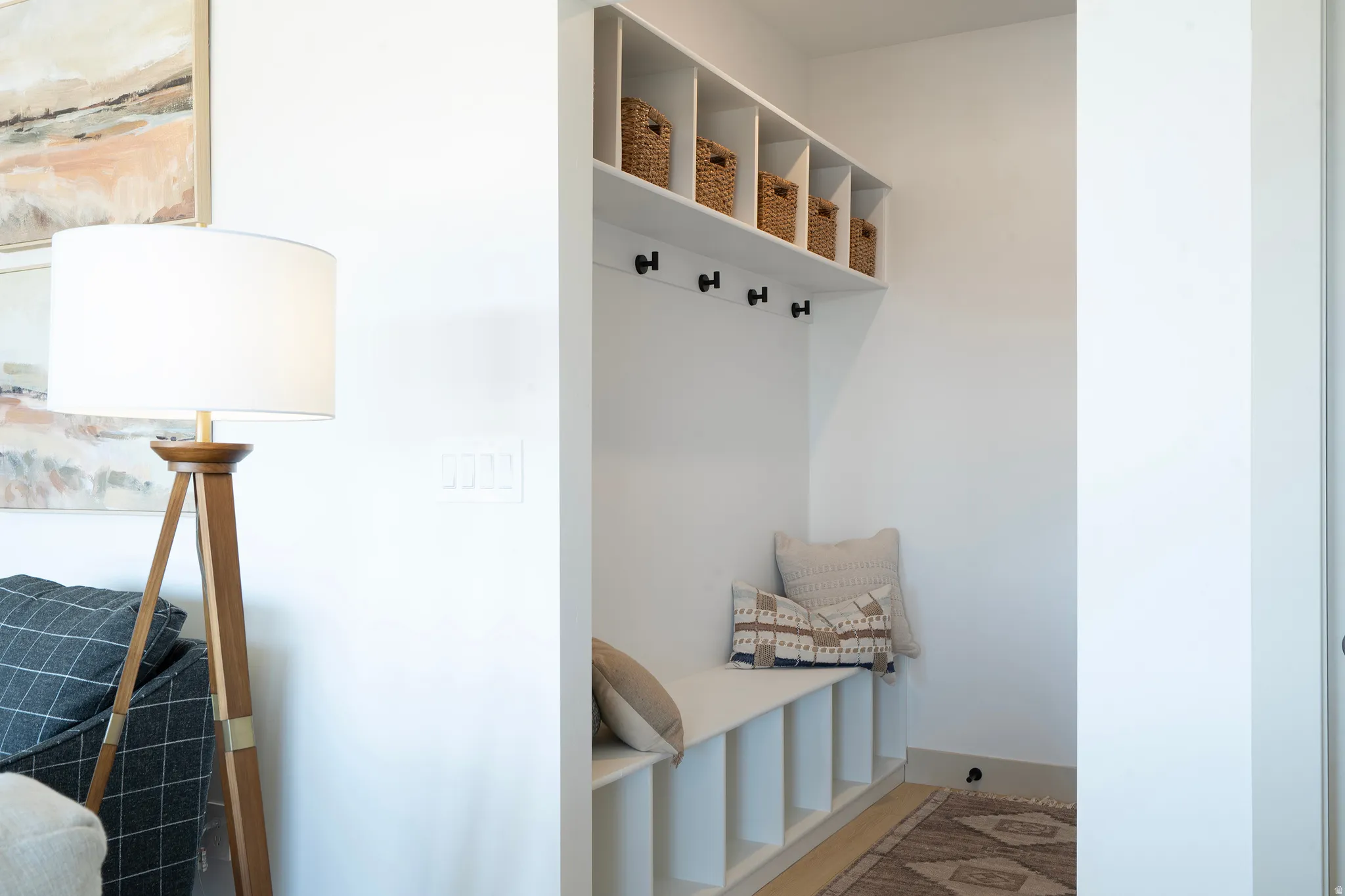 Built-in entryway storage with shelving, bench seating, and wall-mounted hooks