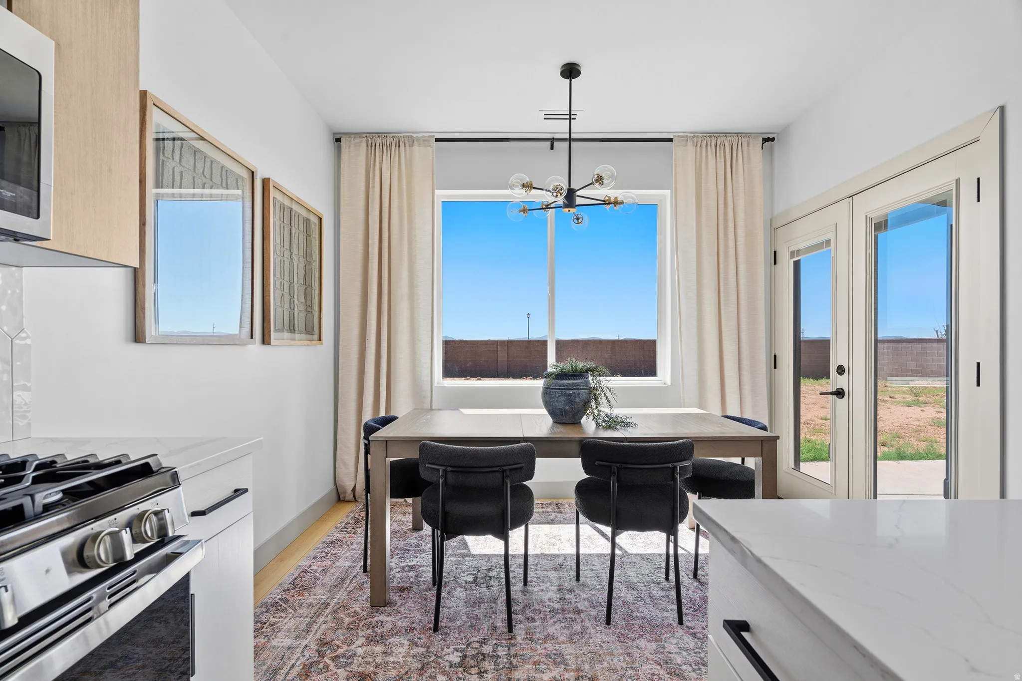 Dining area featuring a contemporary chandelier, large window with expansive views, and wood-finish flooring
