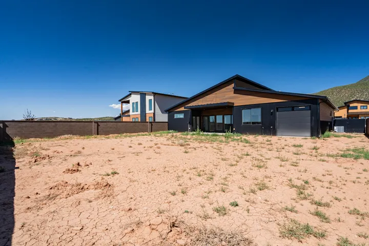 Contemporary exterior with a black facade and wood-finish siding under a dark gabled roof