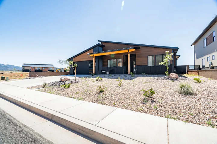 Contemporary exterior featuring wood-finish siding, dark accent panels, and a sloped roofline