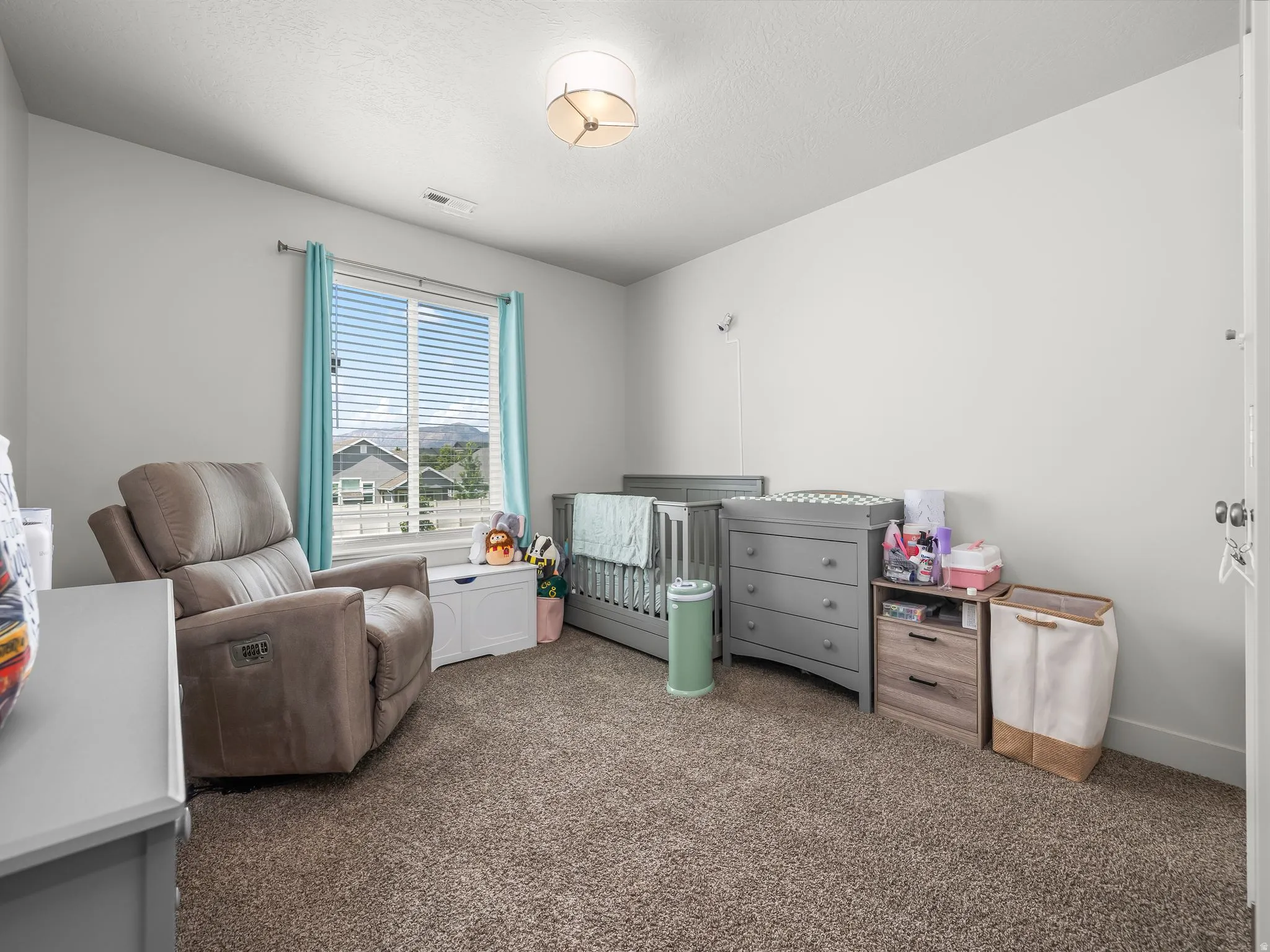 Spacious room with plush carpeting, a large window, and light-colored walls