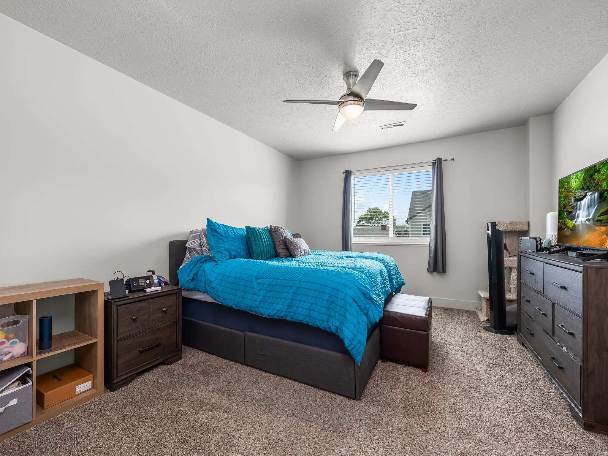 Carpeted bedroom with a window featuring blinds and drapes