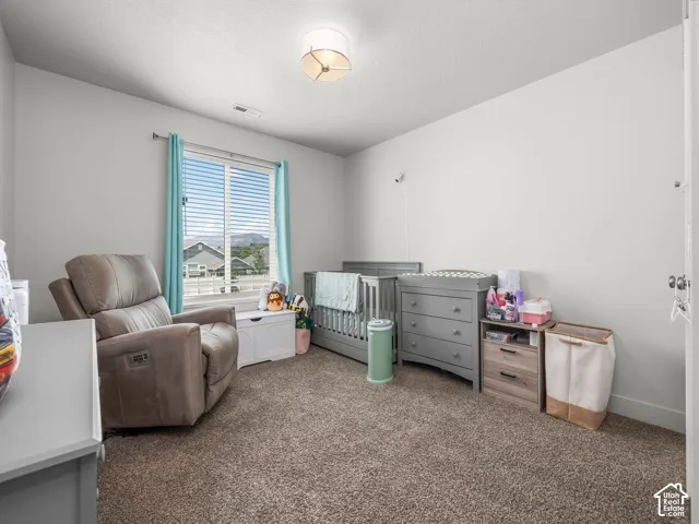 Spacious room with plush carpeting, a large window, and light-colored walls