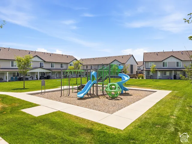 Central playground featuring multiple slides and climbing structures, surrounded by a manicured lawn