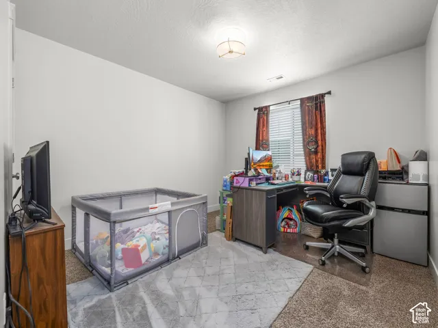 Bright room featuring a window with horizontal blinds, a neutral wall color, and a flush-mount ceiling light fixture