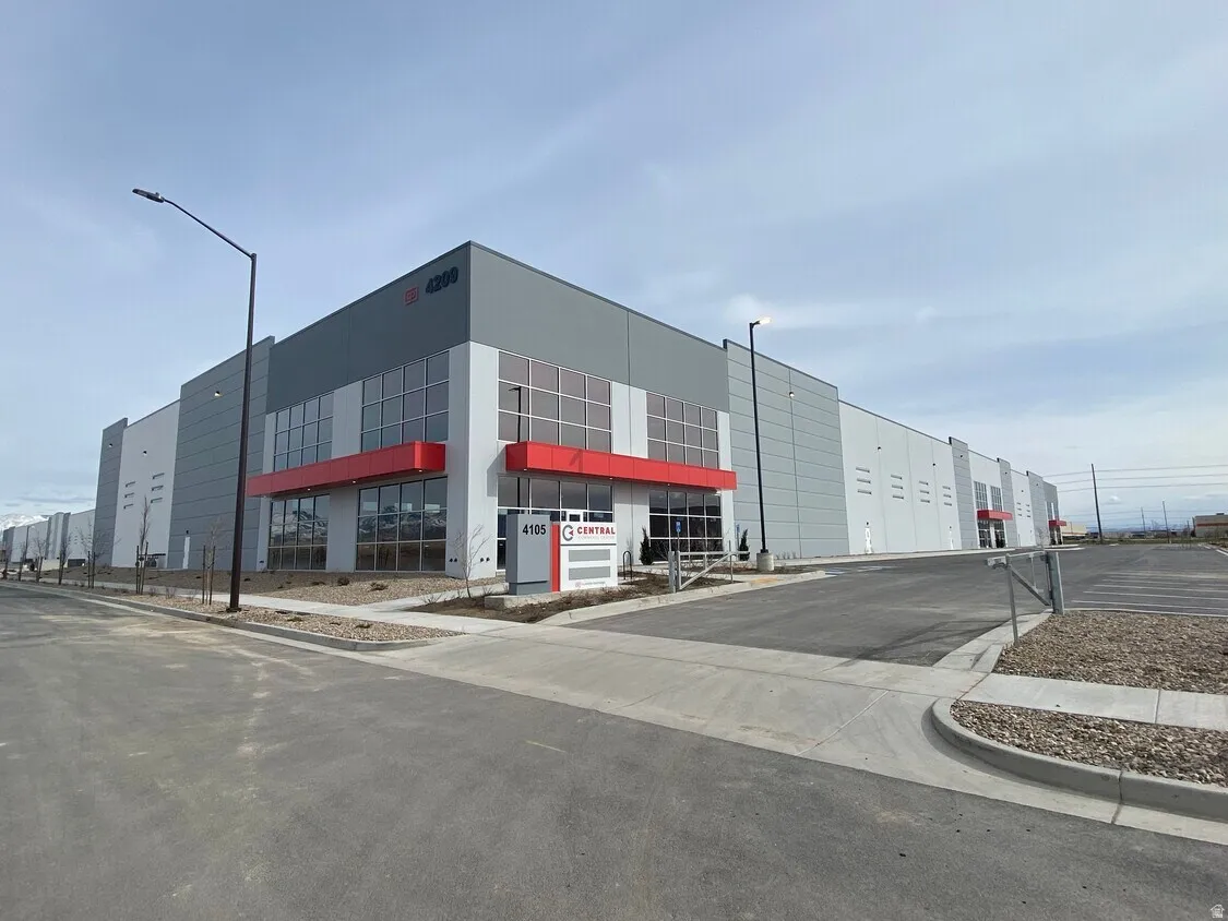 Modern commercial facility featuring a prominent gray facade with red accents and extensive window lines
