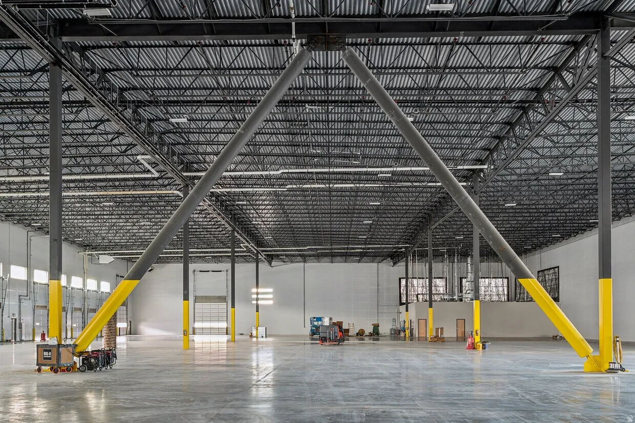 Spacious industrial interior featuring a polished concrete floor and high ceilings with exposed metal trusses