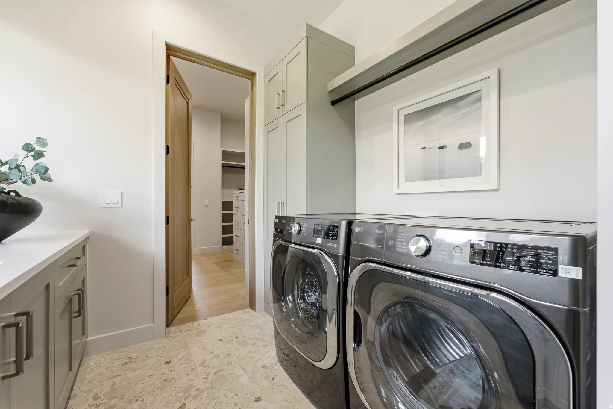 Laundry area featuring integrated appliances, built-in cabinetry, and a countertop