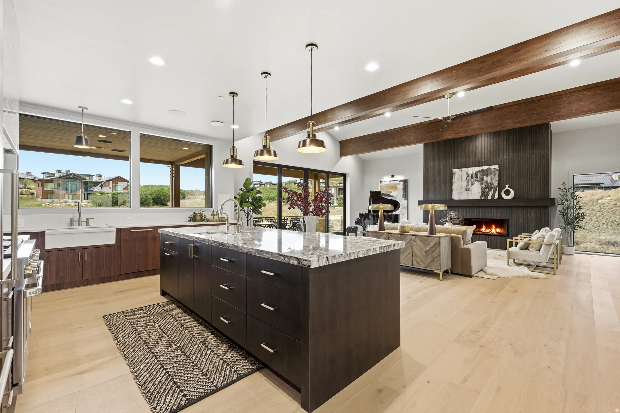 Gourmet kitchen with a large island, wood-finish flooring, and exposed ceiling beams