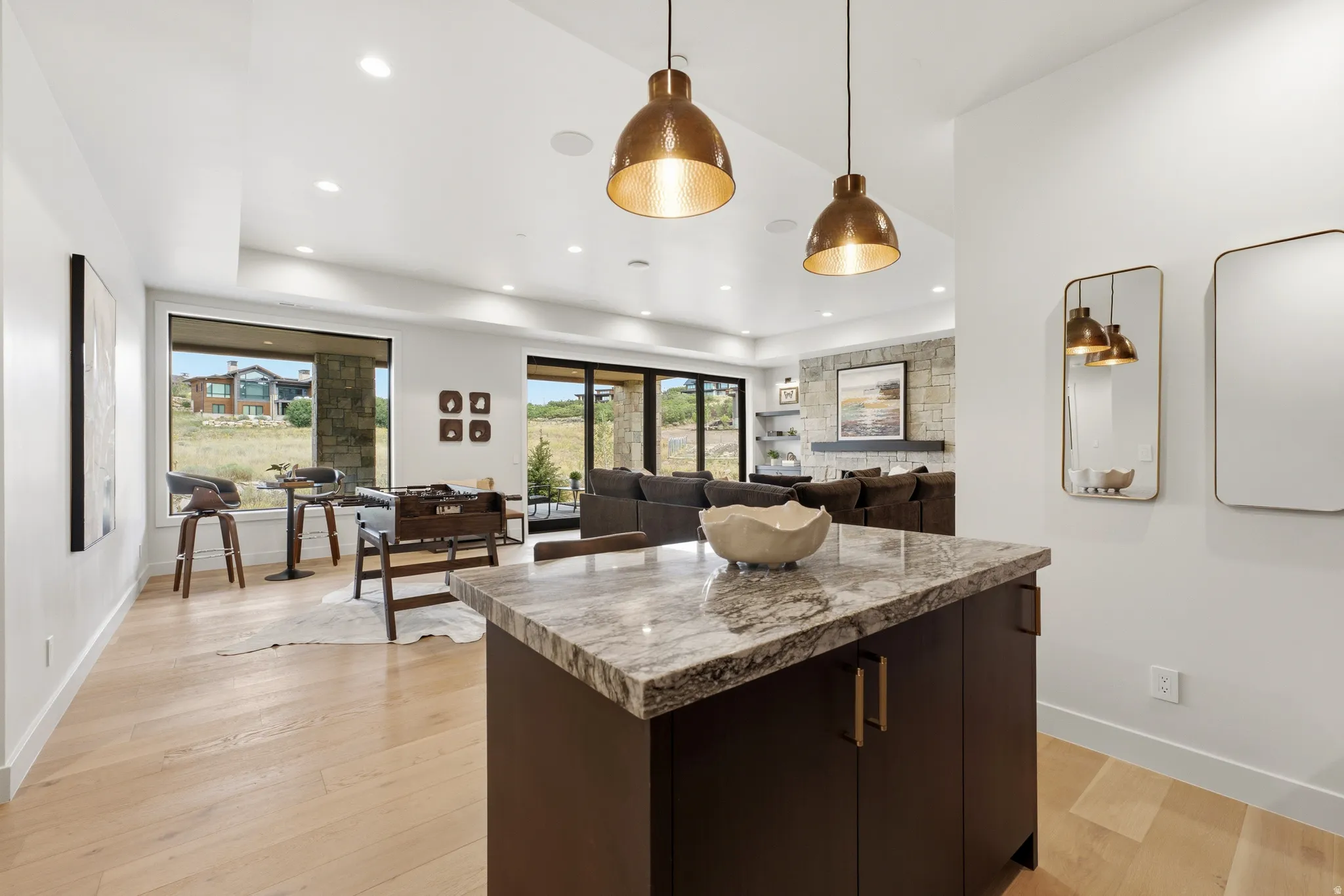 Hardwood flooring, recessed lighting, and a stone-faced fireplace