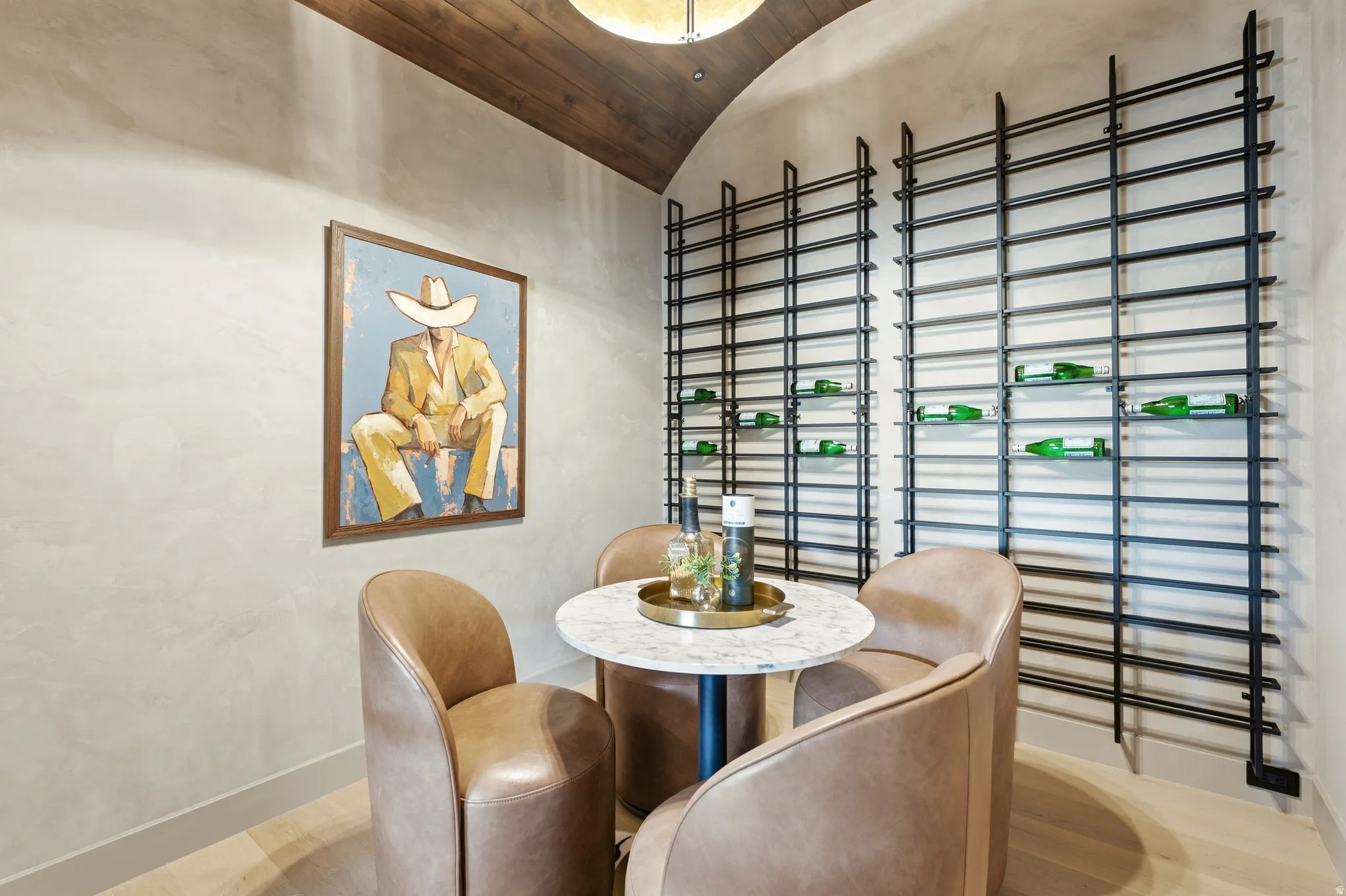 Vaulted wood-finish ceiling, textured wall finish, and built-in metal wine racks with glass shelving