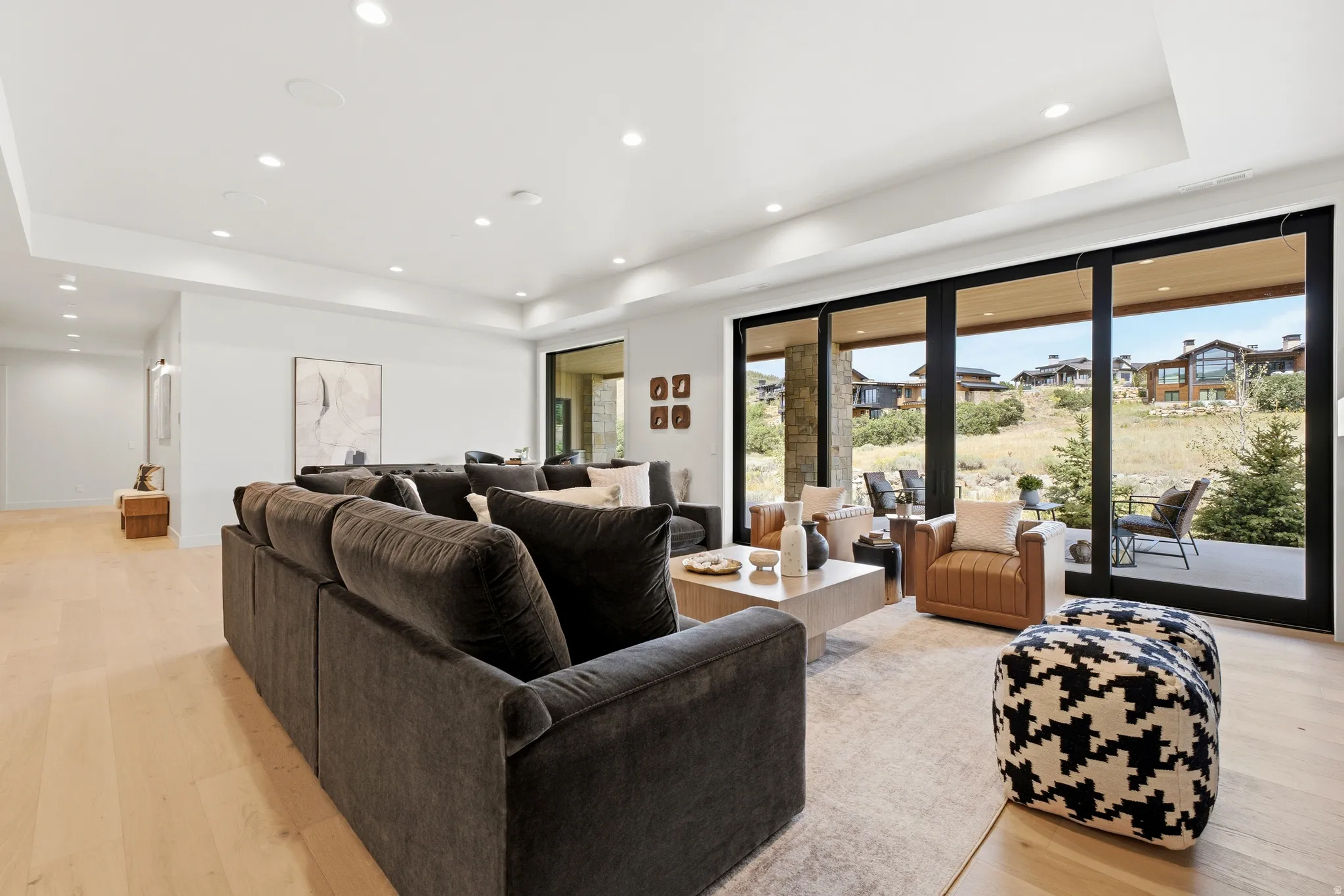 Expansive living space featuring wood-finish flooring, recessed lighting, and a tray ceiling