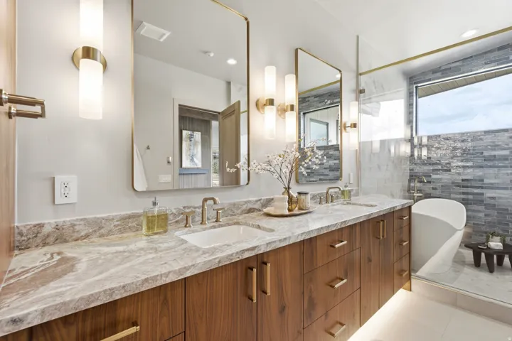 Dual vanity with a stone countertop, under-cabinet lighting, and integrated sinks