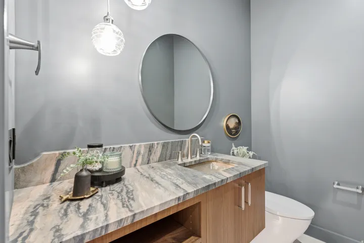 Vanity with an integrated sink, wood-finish cabinetry, and a stone countertop