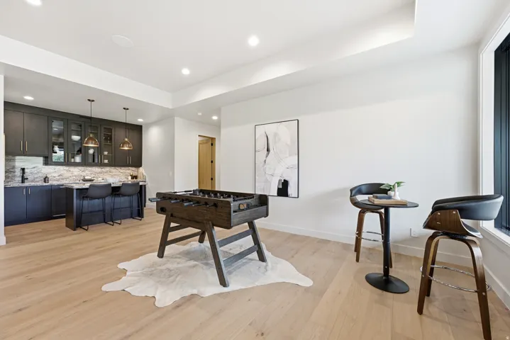 Light wood-finish flooring with a tray ceiling and recessed lighting