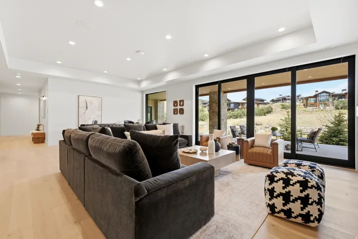 Expansive living space featuring wood-finish flooring, recessed lighting, and a tray ceiling