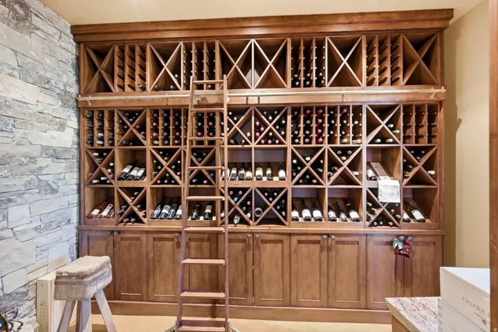 Custom wood-finish wine storage system featuring multiple bottle compartments, full-height design, and integrated base cabinetry