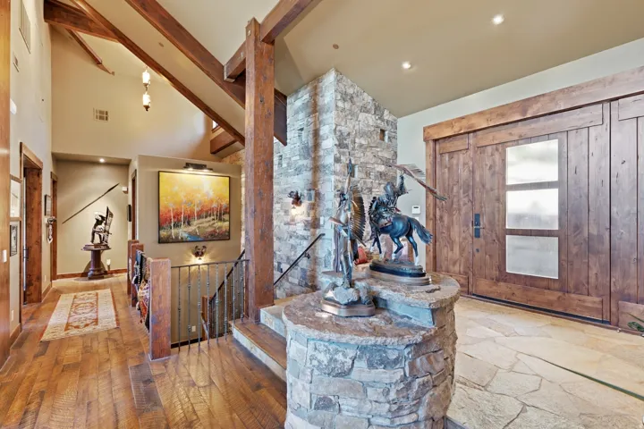 Grand entryway featuring a stone-clad accent wall and flagstone flooring