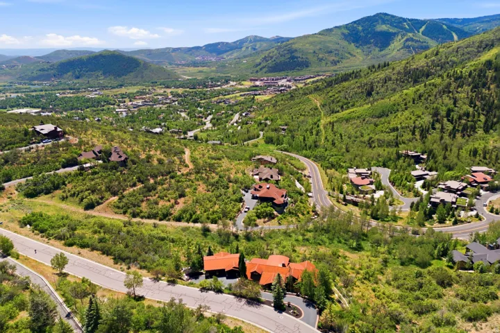 Hillside property featuring a multi-level design with a red tile roof and dark trim