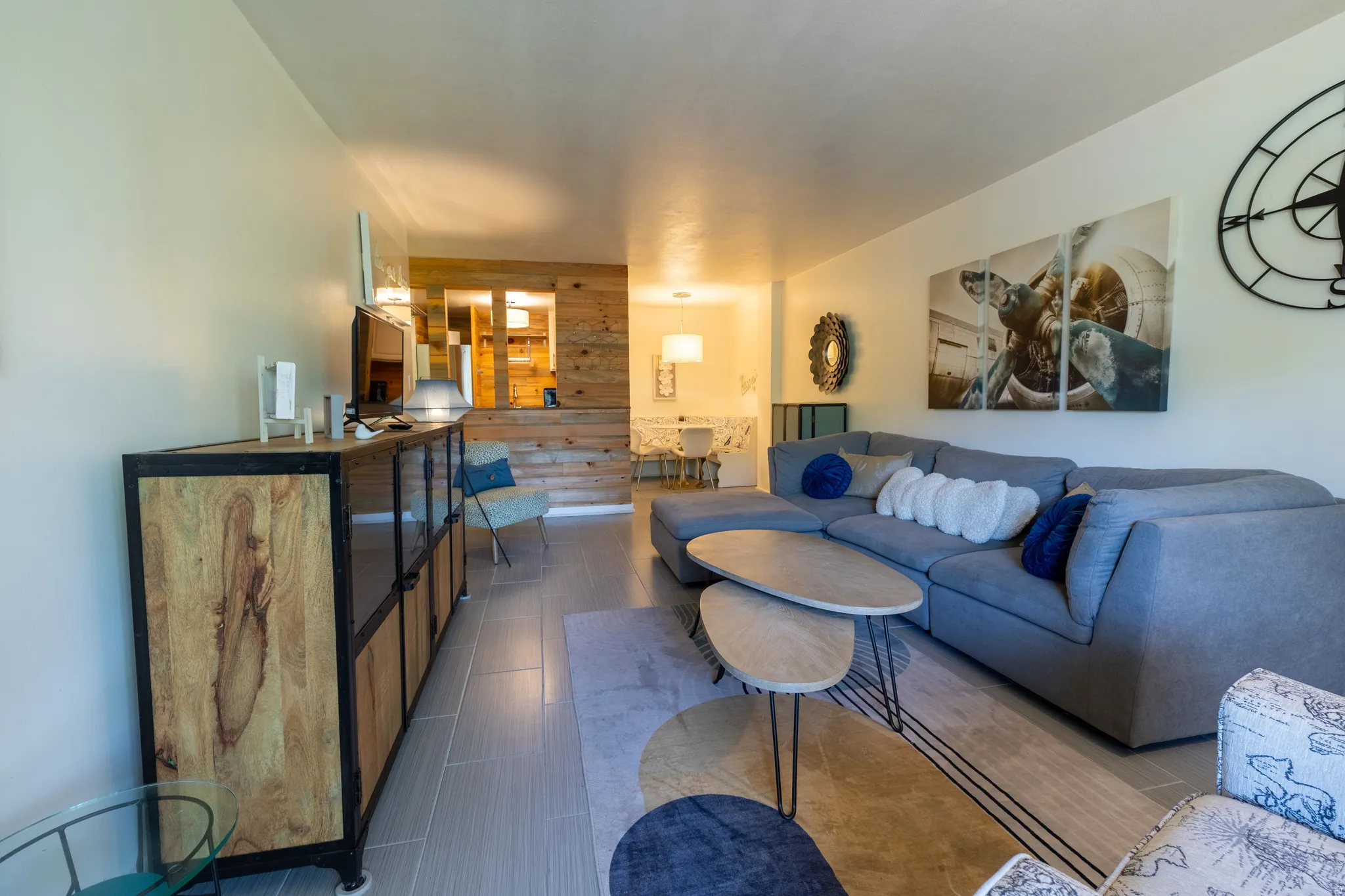 Open-concept living space featuring light wall tones and wood-finish flooring