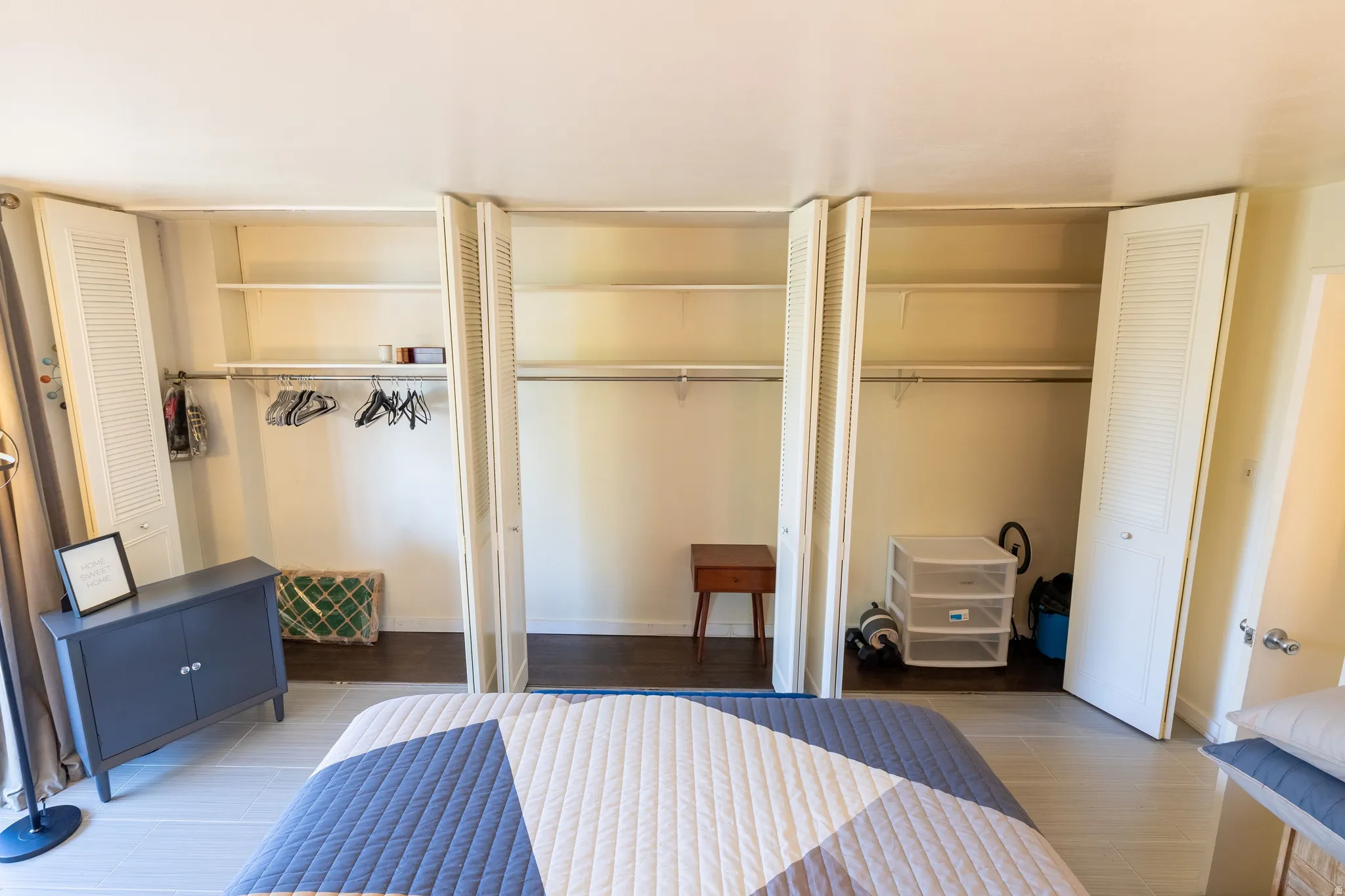 Bedroom featuring light-tone flooring and multiple bi-fold louvered closet doors