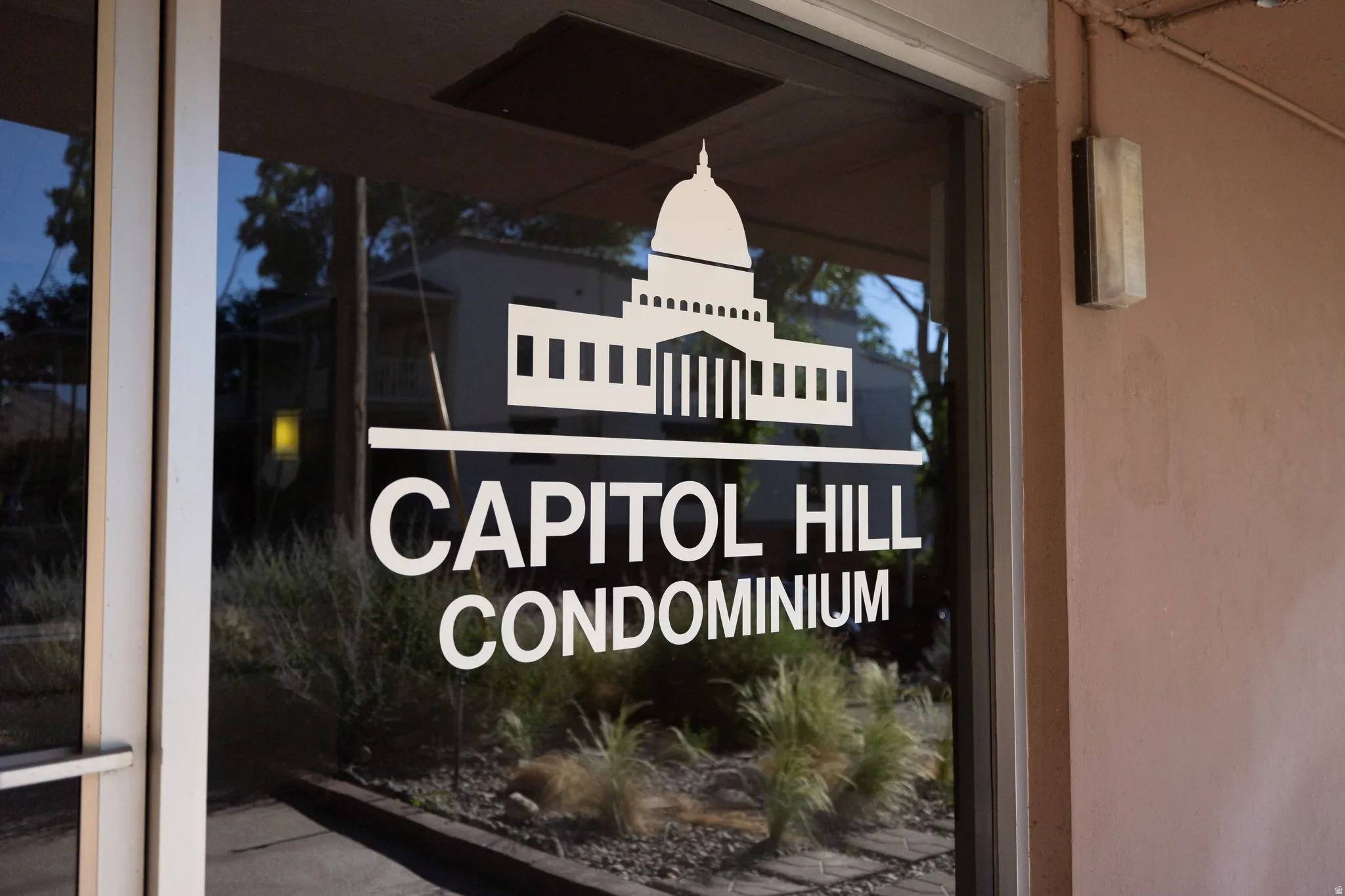 Glass entry door featuring "Capitol Hill Condominium" signage and building logo