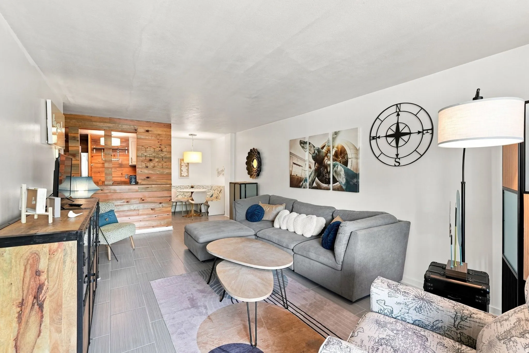 Wood-paneled accent wall, tile flooring, built-in shelving, and recessed lighting