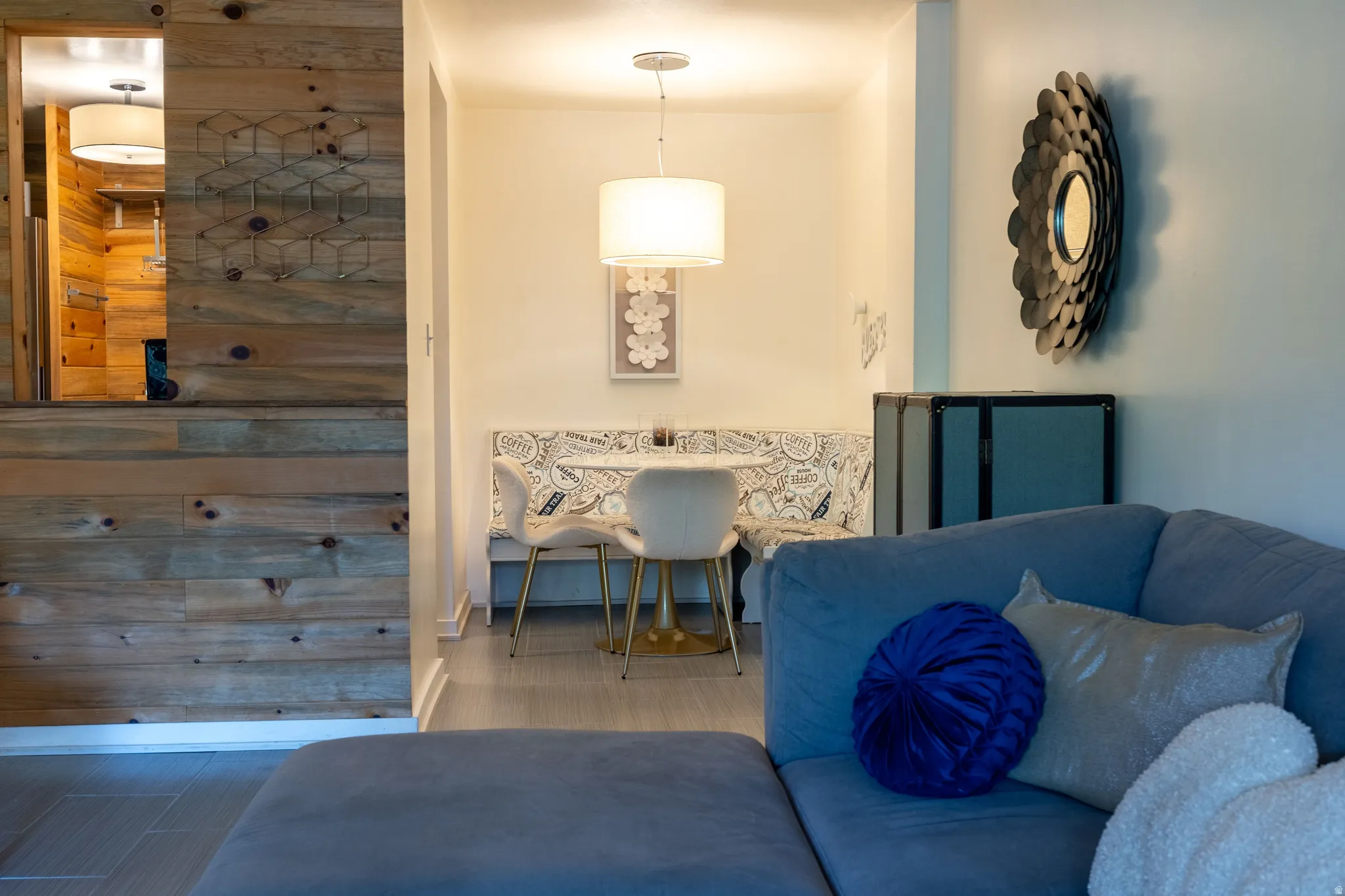 Dining nook with built-in bench seating, pendant lighting, and light wood-finish flooring