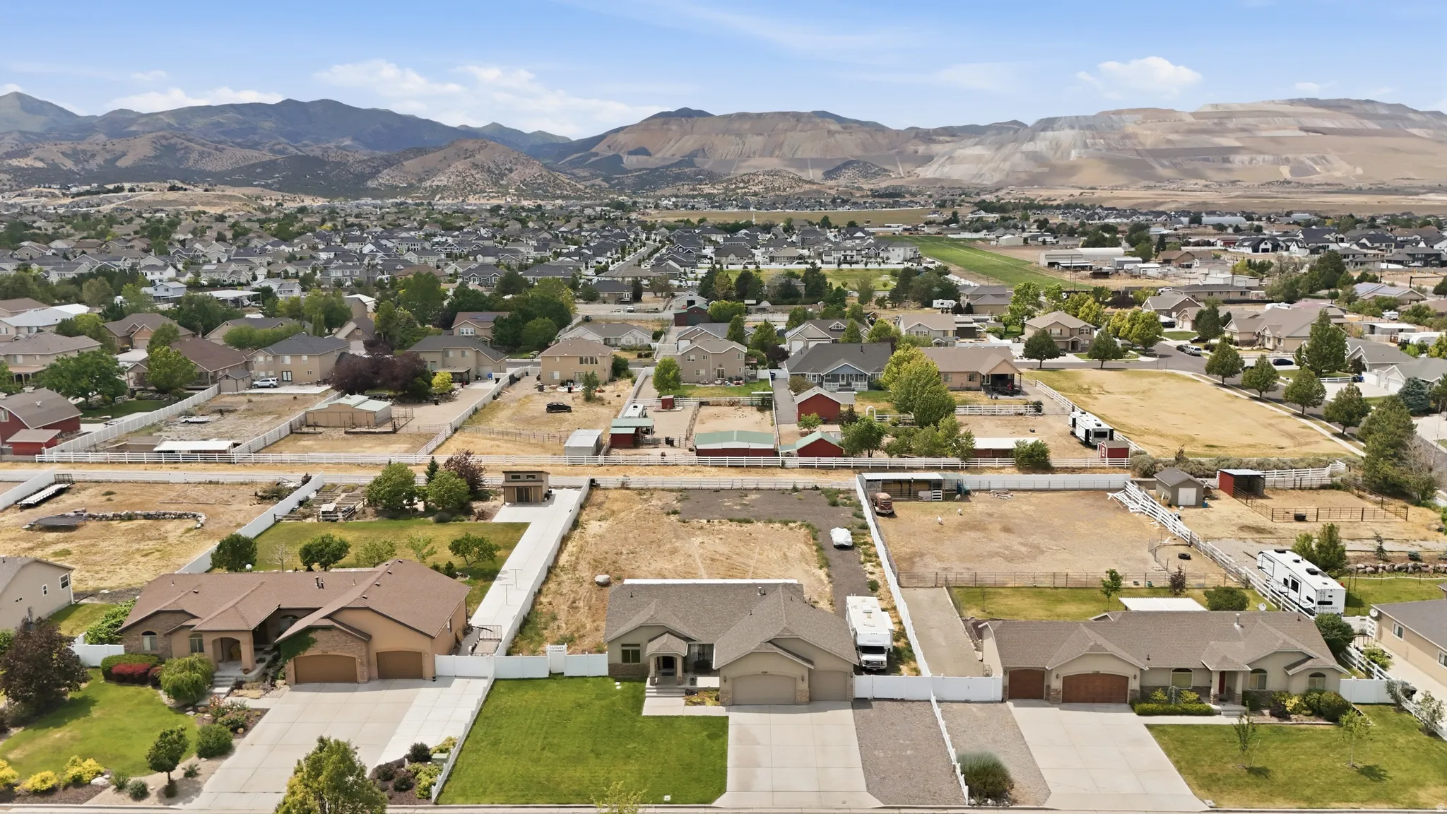Expansive aerial view showcasing residential properties with a mountainous backdrop