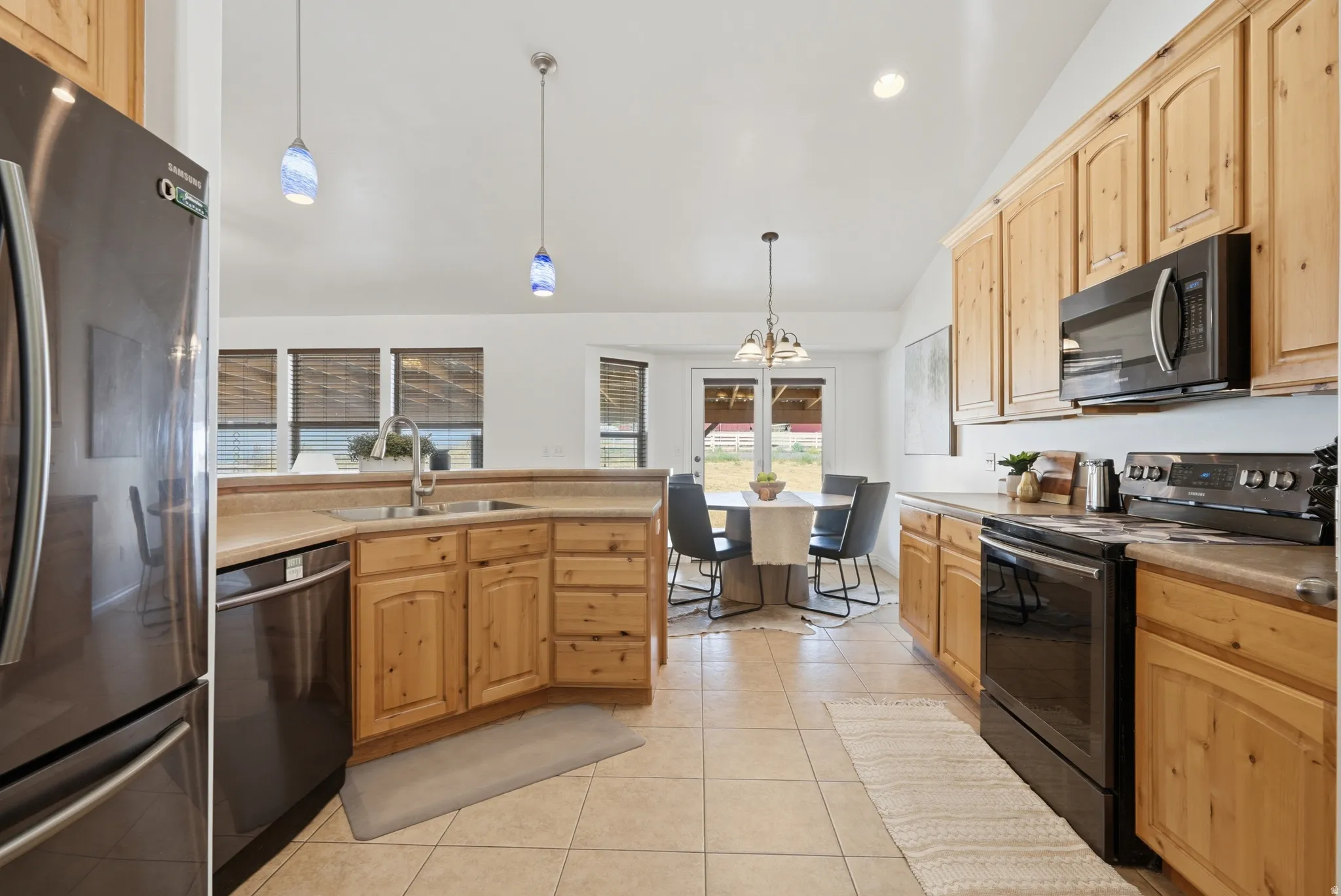 Kitchen featuring wood cabinetry, stone-finish countertops, and black appliances