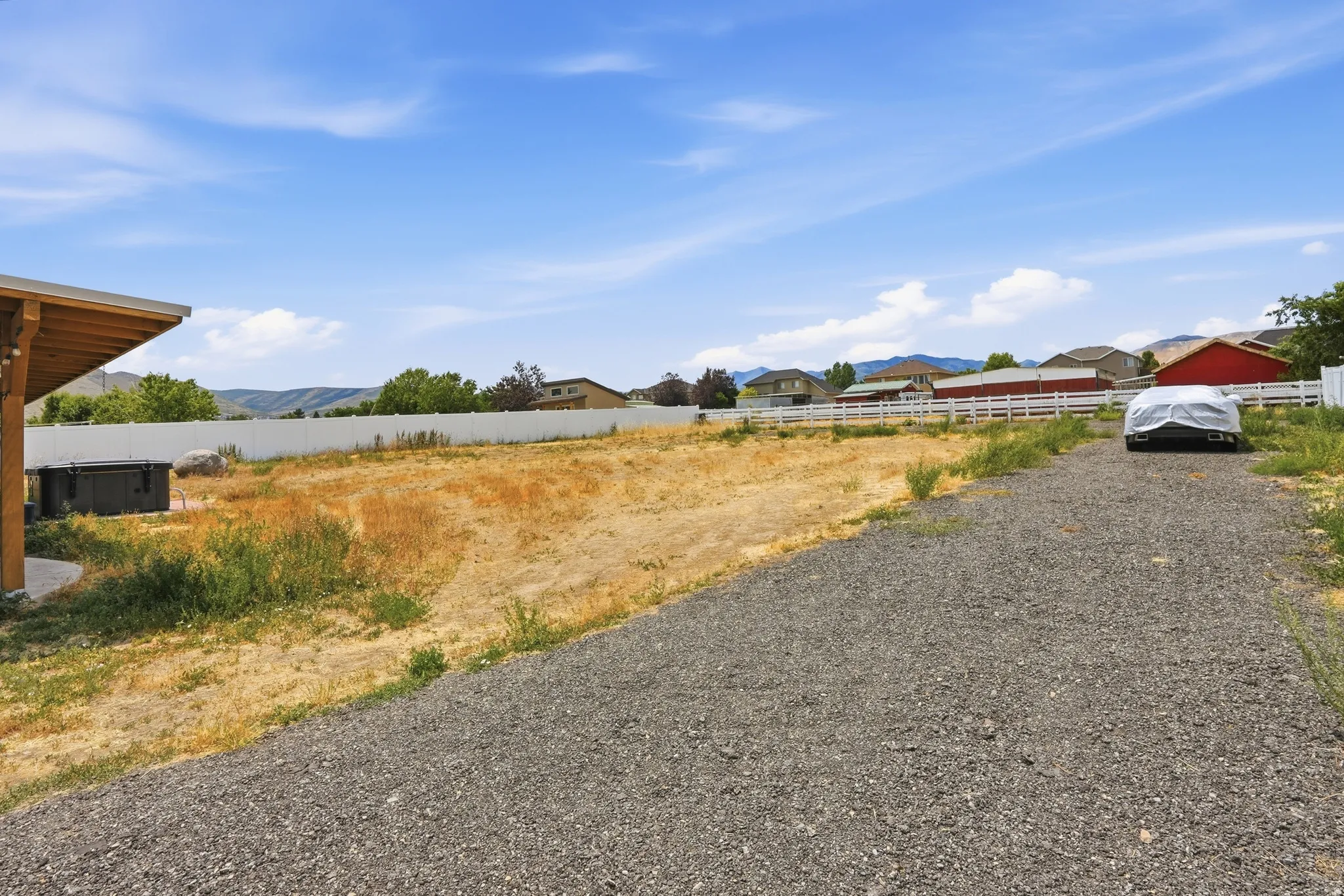 Expansive gravel driveway leading to a large undeveloped lot