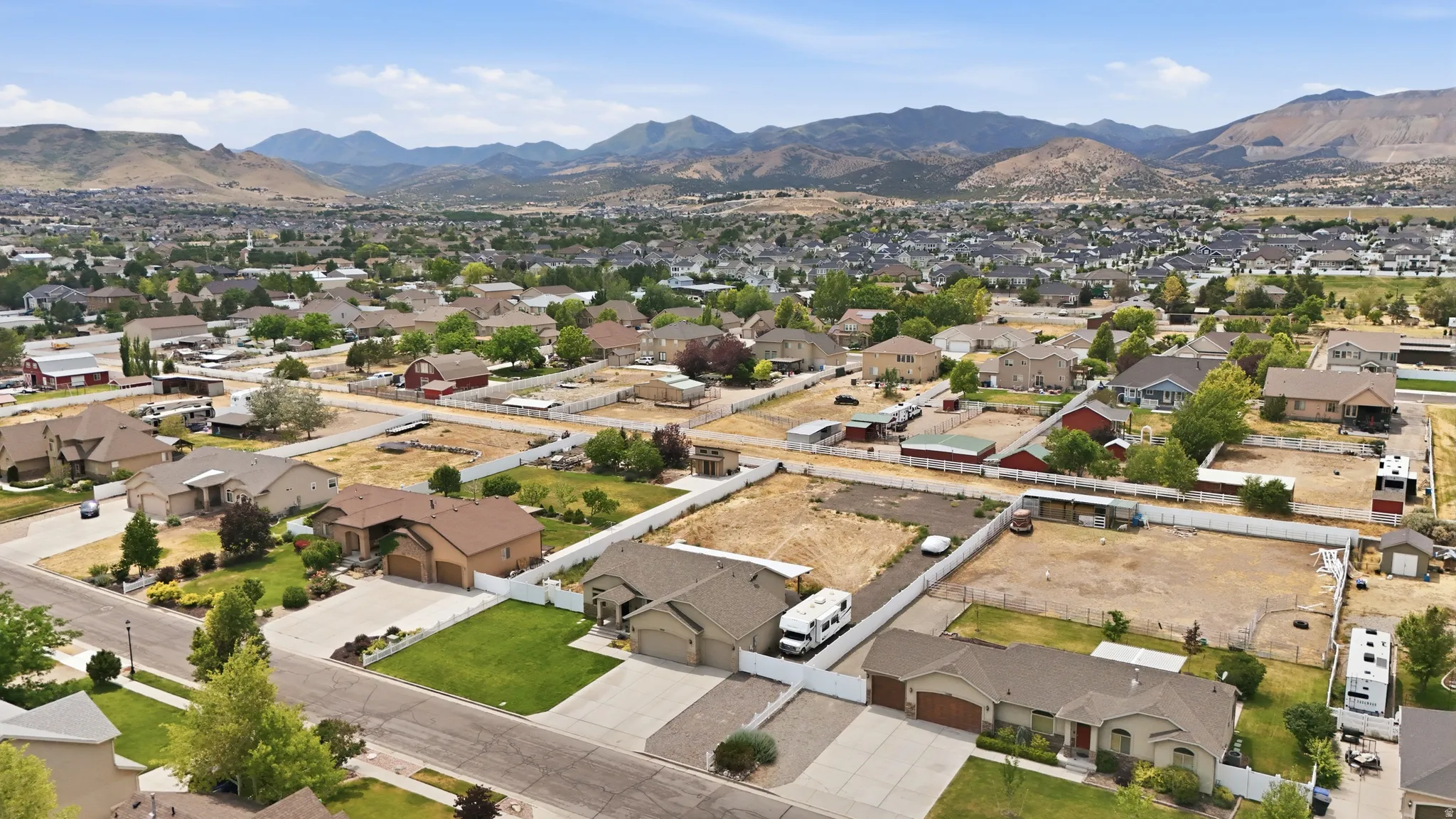 Expansive neighborhood setting featuring a variety of residential properties, clear skies, and distant mountain ranges