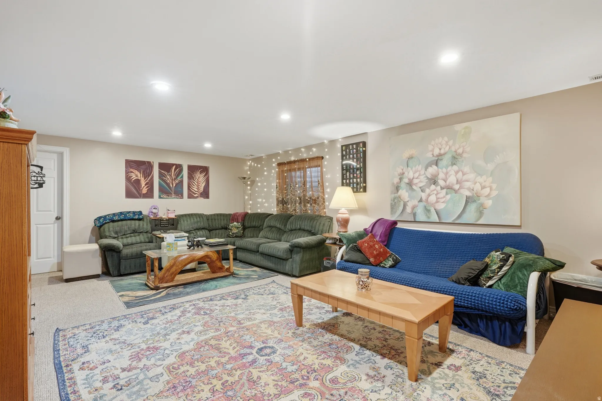 Carpeted living area featuring recessed lighting, painted walls, and a white paneled door