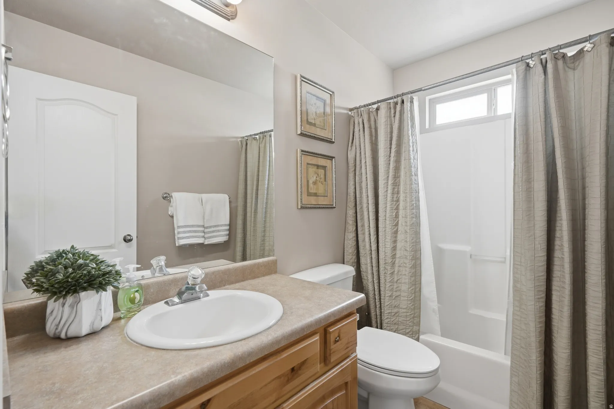 Bathroom featuring a vanity with a laminate countertop, an undermount sink, and a wood-finish cabinet