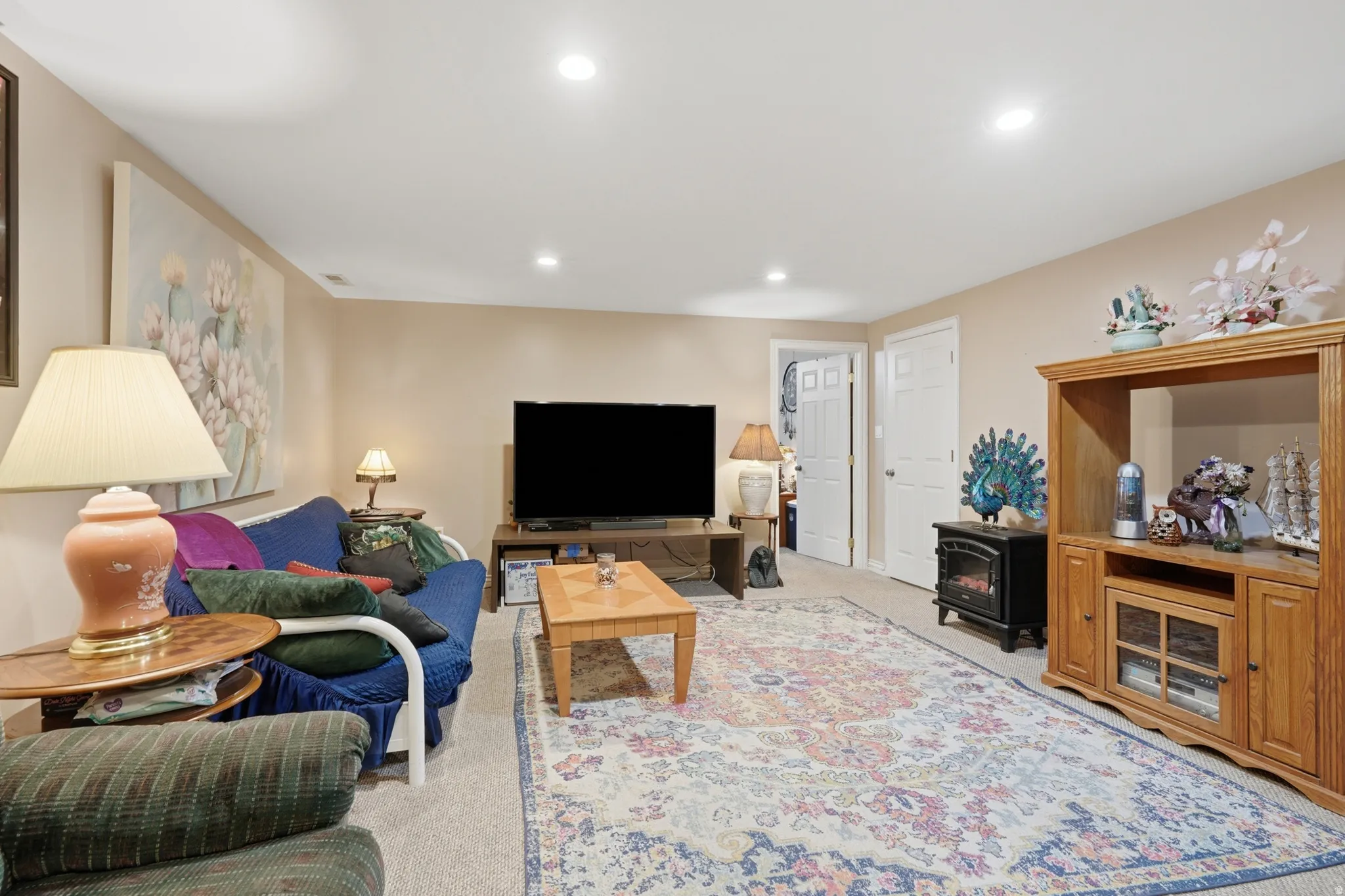 Spacious room featuring neutral-toned walls, recessed lighting, and carpet flooring